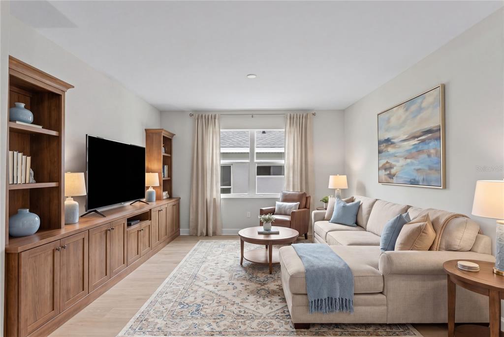 A living room with a sectional sofa, built-in wooden cabinetry, and a large area rug — 956 CLUB CRESSWIND DRIVE, LADY LAKE, FL