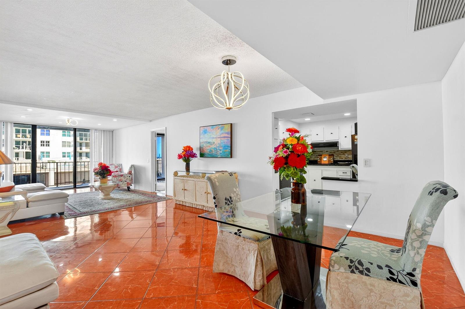 A living and dining area features orange tile floors, white walls, and a glass table — 3456 S Ocean Boulevard # 1040, Palm Beach FL 33480, PALM BEACH, FL
