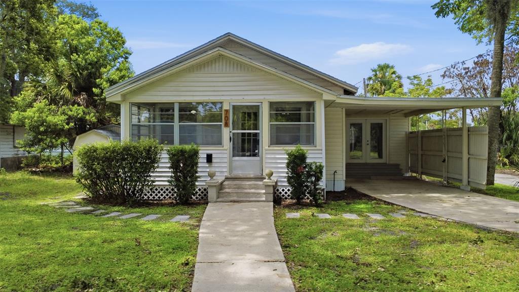 A single-story house with white siding, a front porch, and an attached carport — 708 CELERY AVENUE, SANFORD, FL