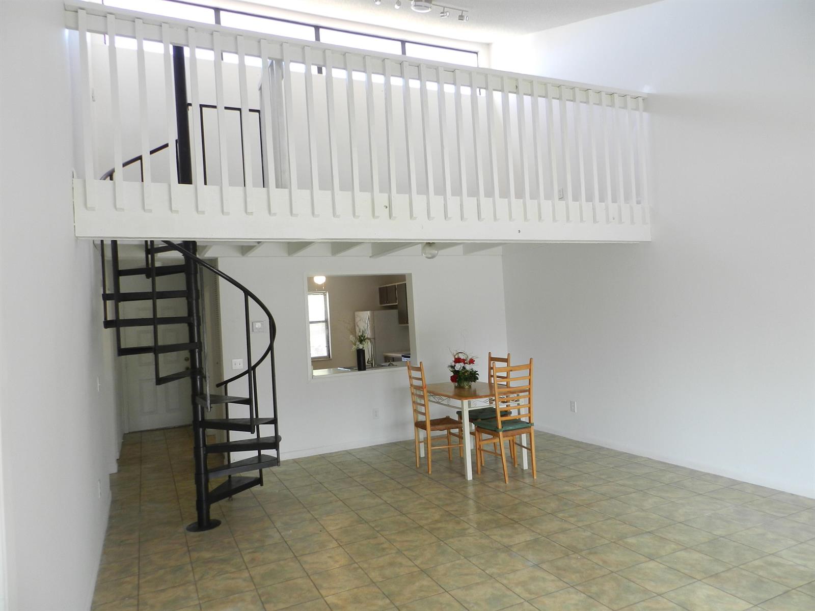 A room with tile flooring, a spiral staircase, a loft area, and a dining set — 1110 E Lakeview Dr Drive E, Royal Palm Beach FL 33411, ROYAL PALM BEACH, FL
