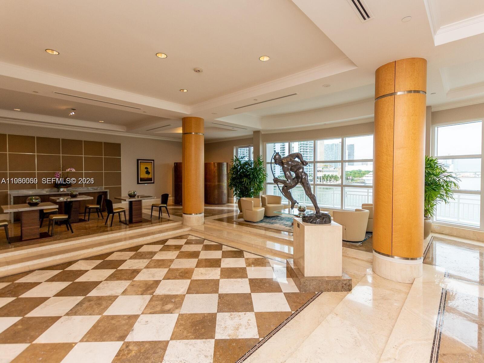 A lobby features a checkered marble floor, large support columns, and a bronze statue — 848 Brickell Key Dr # 1201, Miami FL 33131, MIAMI, FL