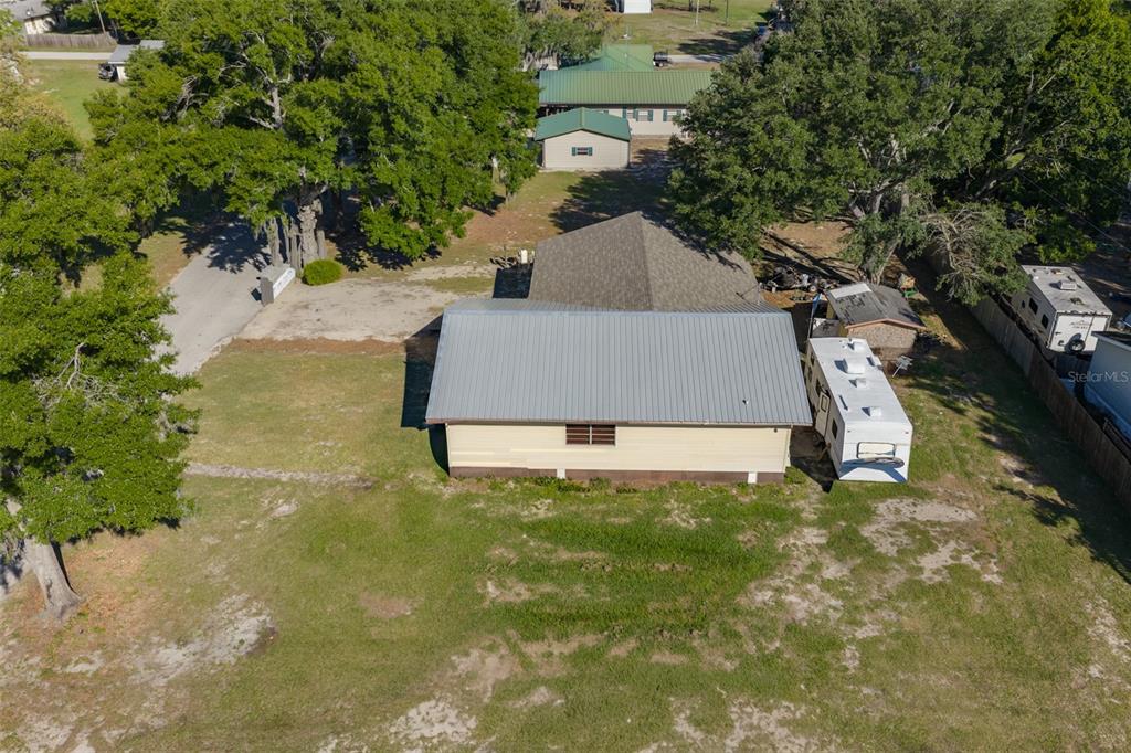 An aerial view shows a house with a metal roof, a detached garage, and trailers — 741 MORREL AVENUE, LAKE WALES, FL