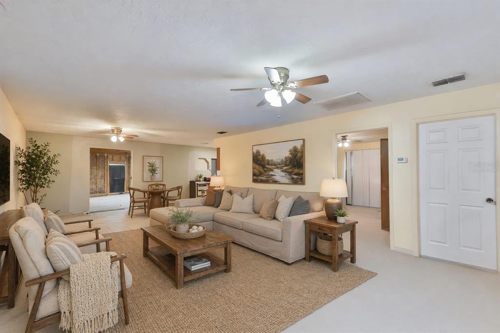 A living room with a beige sectional, wooden coffee table, and an adjacent dining area — 741 MORREL AVENUE, LAKE WALES, FL