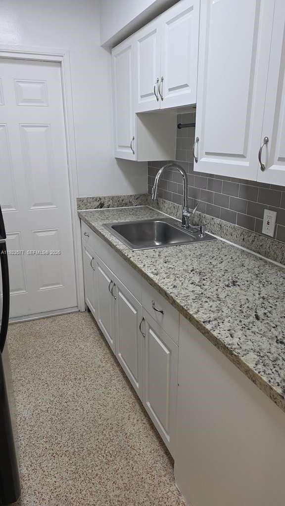 A small bathroom features a white bathtub, a wooden vanity, and a toilet — 790 81st St, Miami Beach FL 33141, MIAMI BEACH, FL