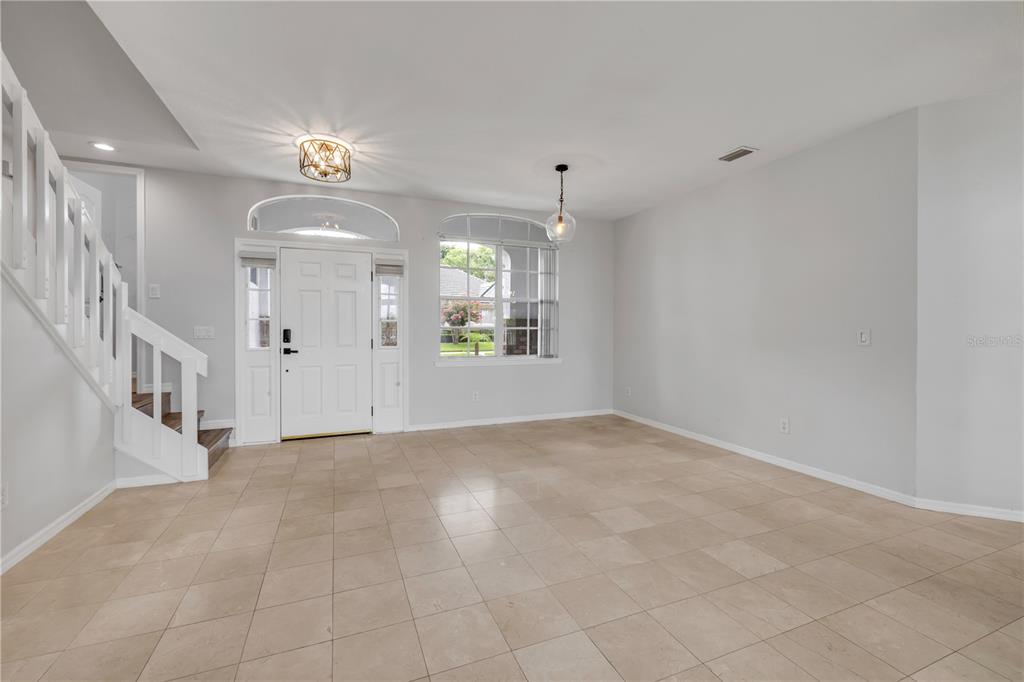 An entryway with tile flooring, a white staircase, and a front door with sidelights — 130 WIMBLEDON CIRCLE, LAKE MARY, FL