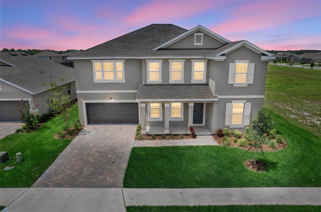 A two-story suburban house with a gray exterior, a paved driveway, and a front porch — 7422 SEA MANATEE STREET, PARRISH, FL