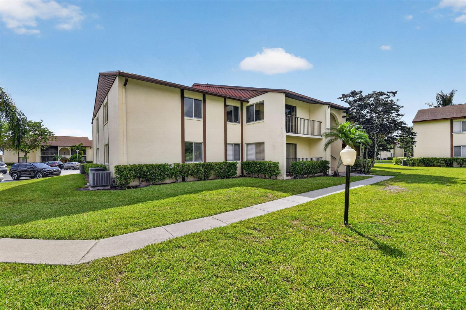 A two-story apartment building with beige stucco walls and a brown metal roof — 4991 Sable Pine Circle # C2, West Palm Beach FL 33417, WEST PALM BEACH, FL
