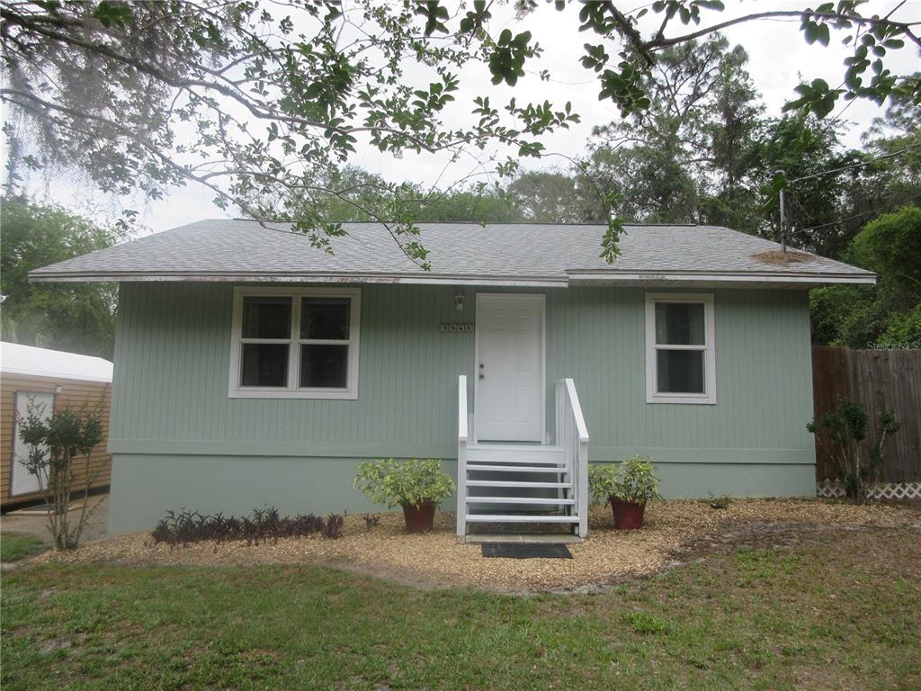 A light green single-story house with a white front door and wooden stairs — 5949 SE 164TH COURT, OCKLAWAHA, FL
