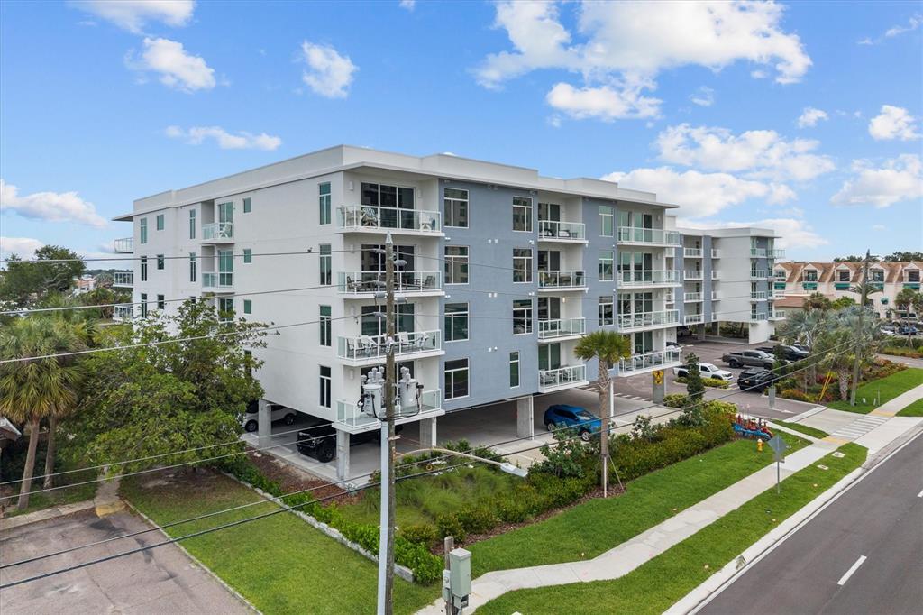 An exterior view of a multi-story apartment building with covered parking and balconies — 415 ISLAND WAY UNIT 311, CLEARWATER BEACH, FL