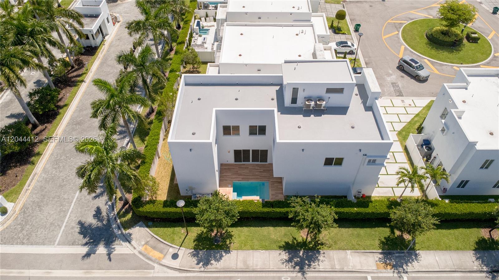 An aerial view shows a modern white house with a small backyard pool and patio — 10381 NW 67th Ter, Doral FL 33178, DORAL, FL