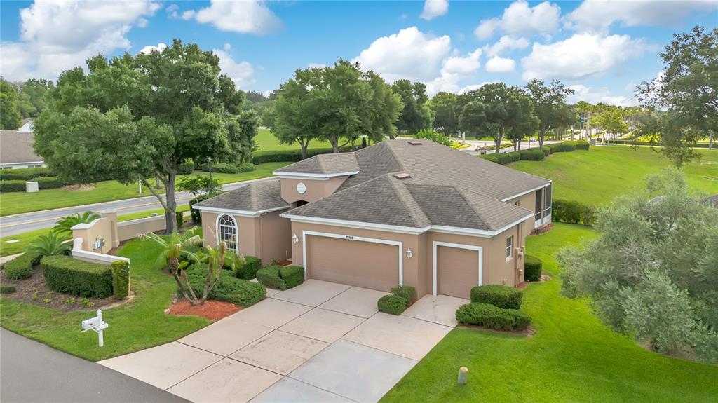 An aerial view of a tan single-story house with a three-car garage and green lawn — 4065 KINGSLEY STREET, CLERMONT, FL