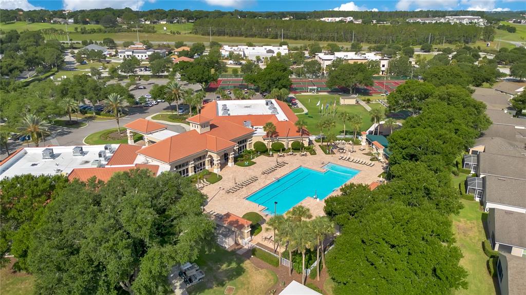 An aerial view shows a community clubhouse with a swimming pool and tennis courts — 4065 KINGSLEY STREET, CLERMONT, FL