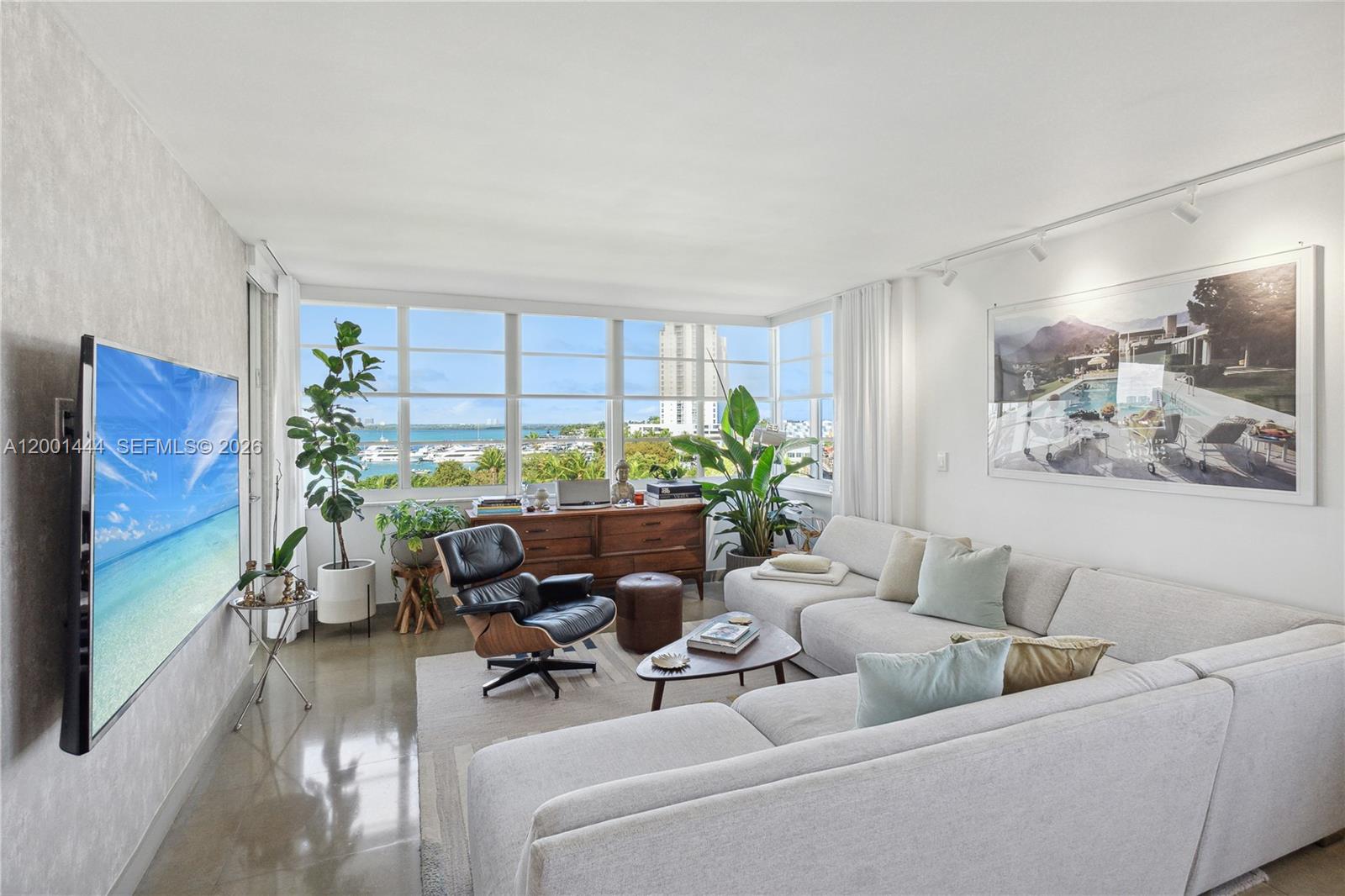 A living room features a large sectional sofa, a lounge chair, and floor-to-ceiling windows — 1670 lincoln Ct, Miami Beach FL 33139, MIAMI BEACH, FL