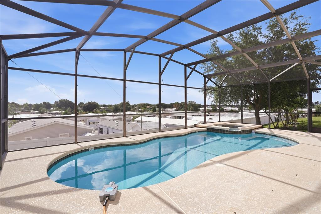 An outdoor swimming pool and hot tub are enclosed within a screened-in lanai — 722 CADIZ LOOP, DAVENPORT, FL