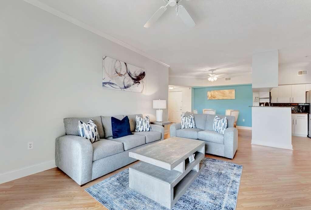 A living room features two gray sofas, a wooden coffee table, and light wood flooring — 2417 Tuscany Way # 2417, Boynton Beach FL 33435, BOYNTON BEACH, FL