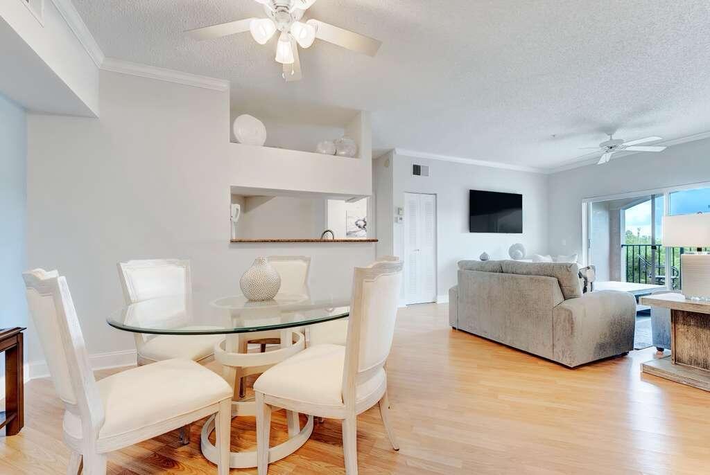 A dining area with a glass table and chairs opens into a living room — 2417 Tuscany Way # 2417, Boynton Beach FL 33435, BOYNTON BEACH, FL