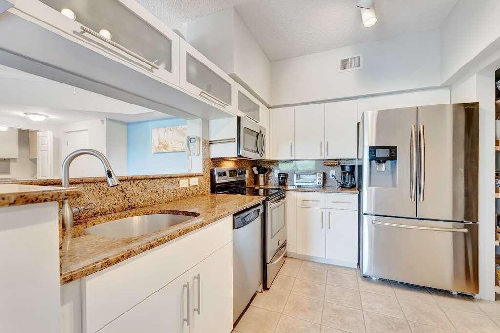 A kitchen with white cabinets, granite countertops, and stainless steel appliances — 2417 Tuscany Way # 2417, Boynton Beach FL 33435, BOYNTON BEACH, FL