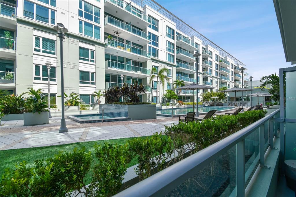 A view of a modern apartment complex courtyard featuring a swimming pool and patio area — 912 CHANNELSIDE DRIVE UNIT 2316, TAMPA, FL