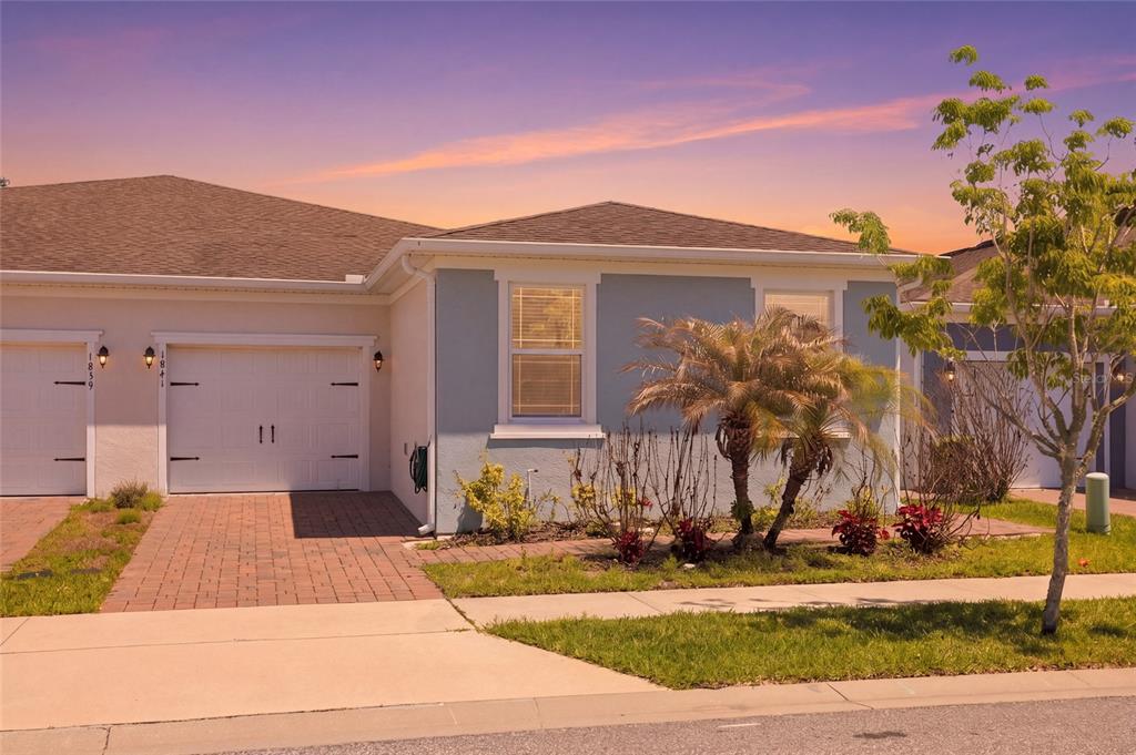 A light blue single-story house with a white garage door and a paved driveway — 1841 OVERCUP AVENUE, ST CLOUD, FL