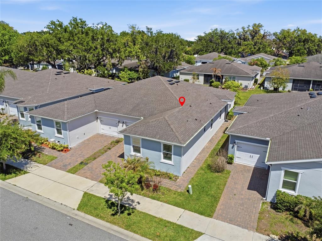 An aerial view shows several light-blue single-story houses with gray shingled roofs and driveways — 1841 OVERCUP AVENUE, ST CLOUD, FL