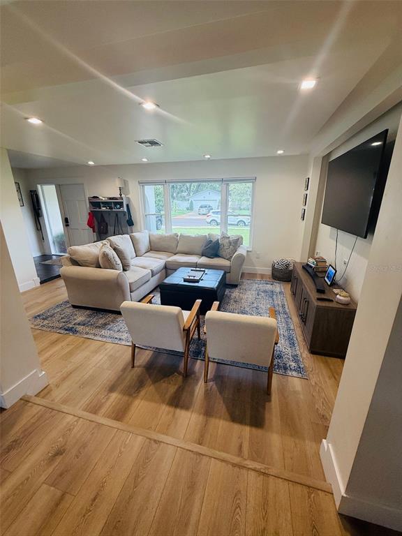 A living room features a sectional sofa, two armchairs, a television, and wood flooring — 1956 JAPONICA ROAD, WINTER PARK, FL