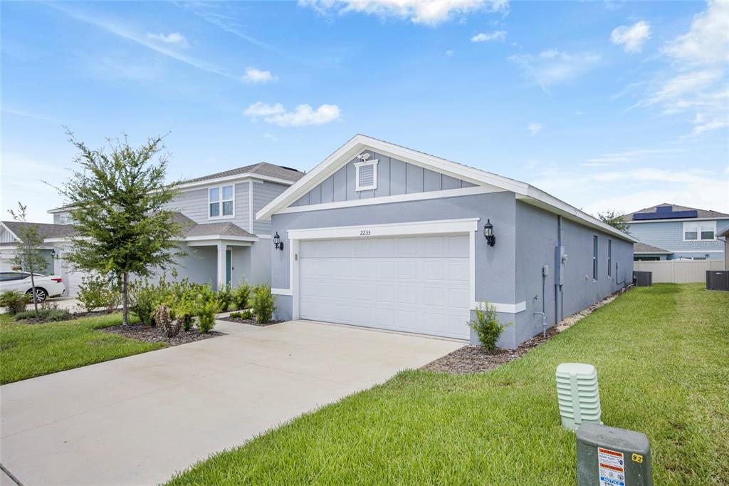 A light blue single-story house with a two-car garage and a concrete driveway — 2235 LOVELY LANE, DAVENPORT, FL