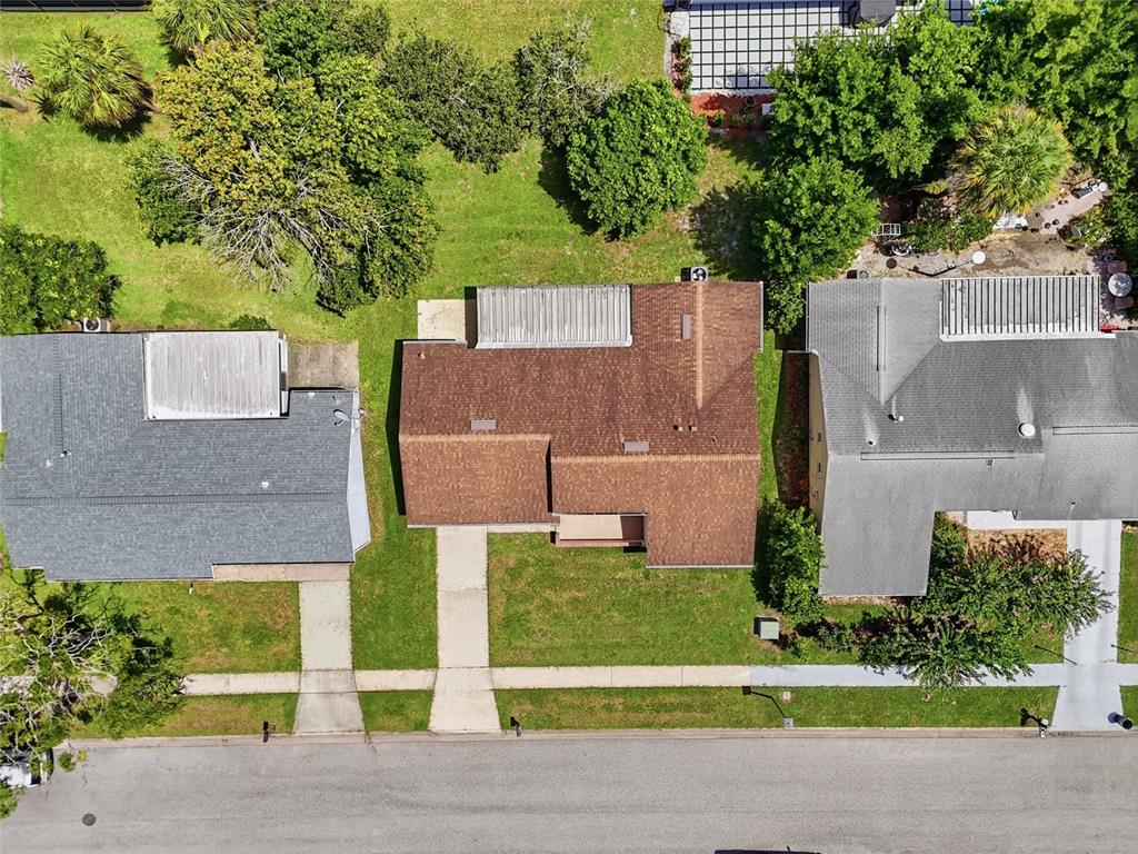 An aerial view shows three suburban houses with brown and gray roofs along a street — 4917 GOUCHER LANE, ORLANDO, FL