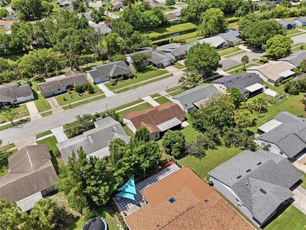 An aerial view shows a suburban neighborhood with single-family homes, paved streets, and green lawns — 4917 GOUCHER LANE, ORLANDO, FL
