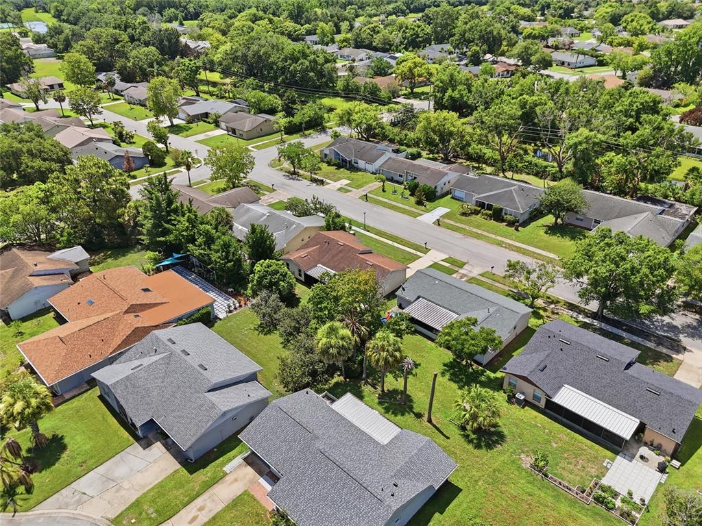 An aerial view shows a suburban neighborhood with single-family homes, paved streets, and mature trees — 4917 GOUCHER LANE, ORLANDO, FL