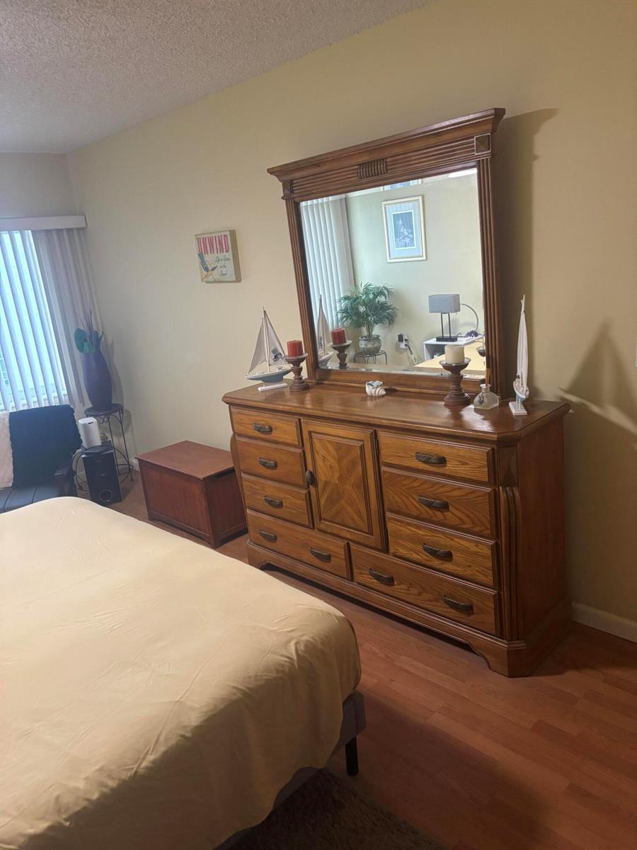 A bedroom features a large wooden dresser with a mirror, a bed, and nautical decor — 6670 Royal Palm Boulevard # 308k, Margate FL 33063, MARGATE, FL