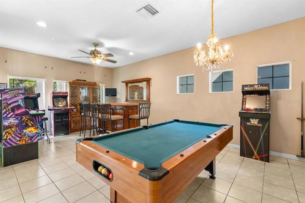 A game room features a pool table, a bar with stools, and three arcade cabinets — 444 YORK DALE DRIVE, RUSKIN, FL
