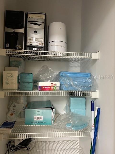 A wire shelving unit in a closet holds medical supplies, electronics, and cleaning tools — 6333 E STATE RD 54 ROAD E UNIT 6333, NEW PORT RICHEY, FL