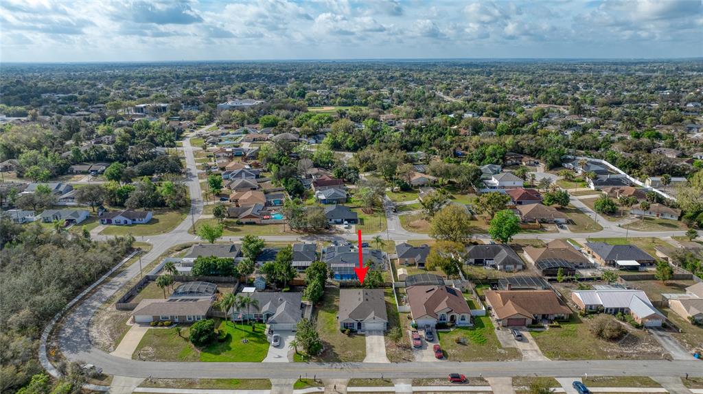An aerial view shows a single-story house with a gray roof in a suburban neighborhood — 725 N FIRWOOD DRIVE, DELTONA, FL