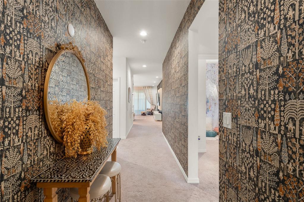 A hallway features dark patterned wallpaper, a console table with a mirror, and carpeted flooring — 1195 CRANE TALON WAY, SANFORD, FL