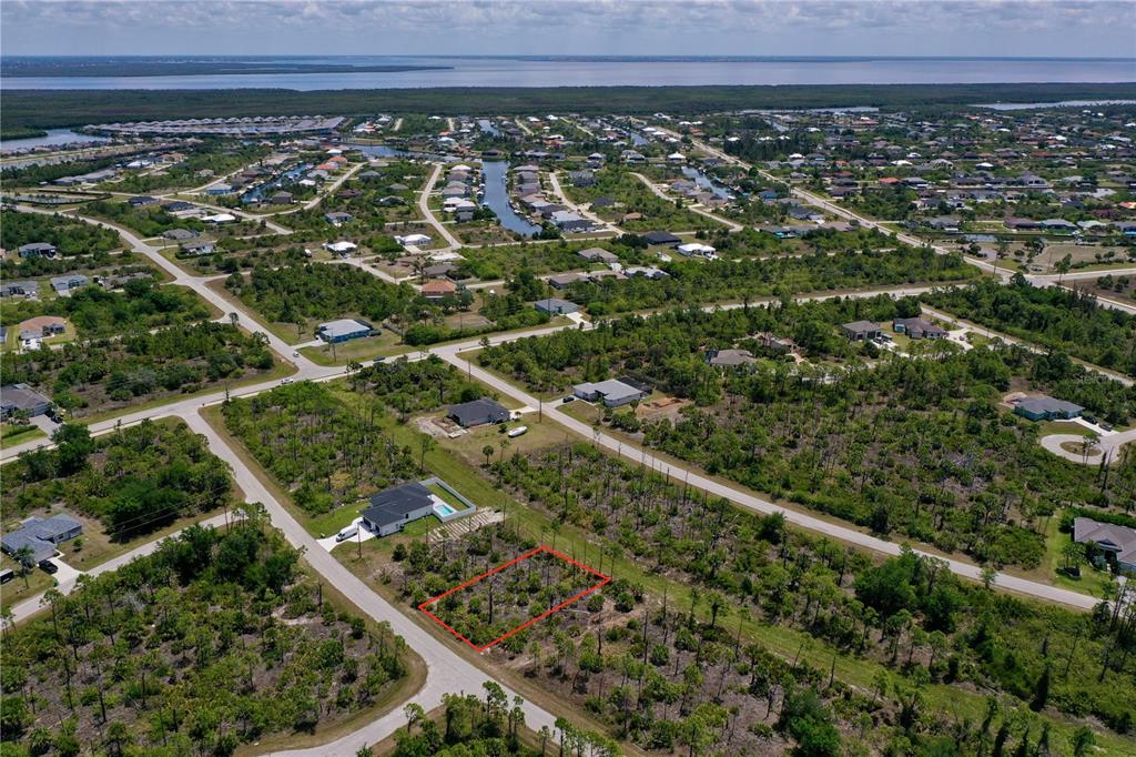 An aerial view shows a vacant, rectangular lot outlined in red within a residential neighborhood — 8228 LEAFY WAY, PORT CHARLOTTE, FL