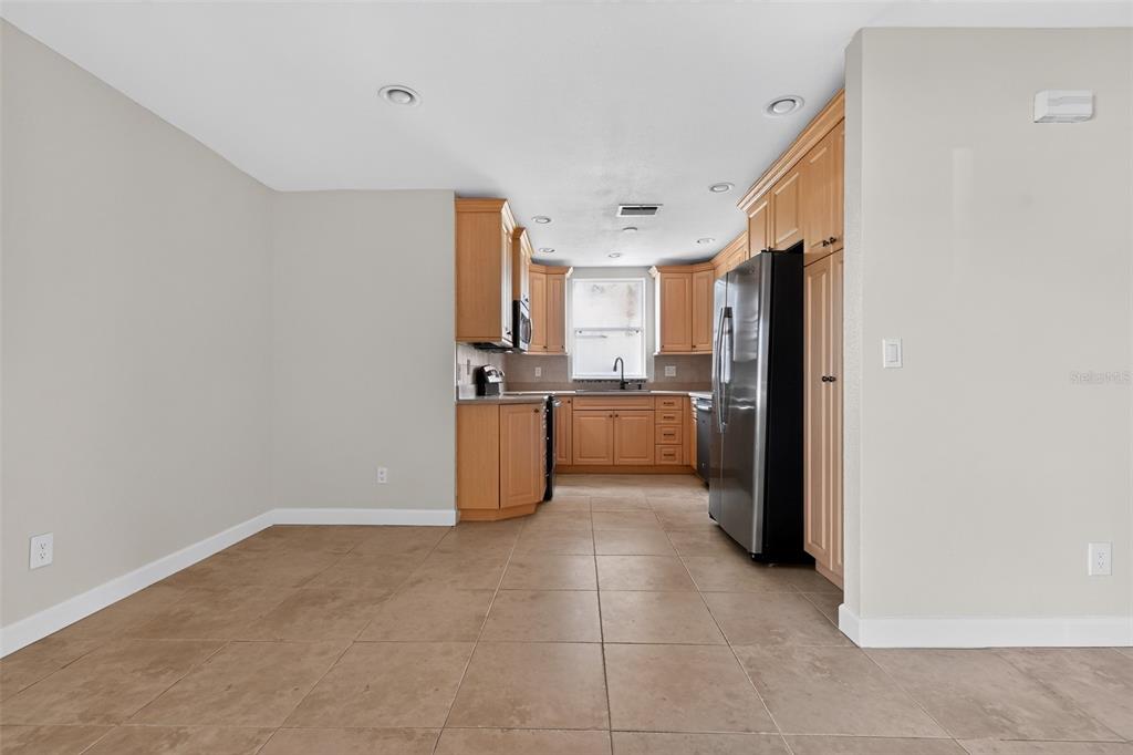 A kitchen with light wood cabinets, stainless steel appliances, and tan tile flooring — 2221 ALEXANDER DRIVE, TITUSVILLE, FL