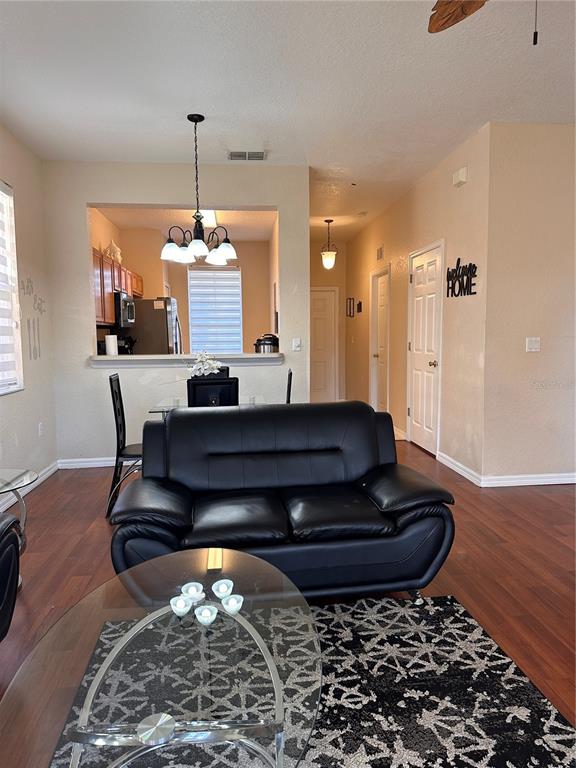 A living room features a black leather loveseat, a glass coffee table, and a dining area — 141 LA MIRAGE STREET, DAVENPORT, FL