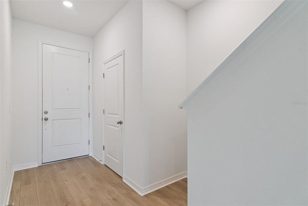 A white front door and a smaller closet door sit on light wood-look flooring — 1108 CYPRESS ELM DRIVE, DELAND, FL