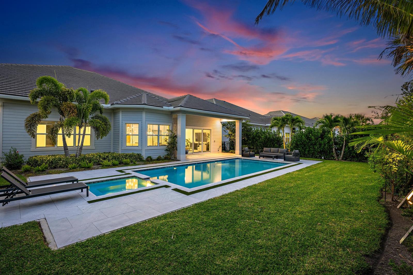 A backyard with a swimming pool, lounge chairs, and a patio attached to a house — 9338 Crestview Circle, Palm Beach Gardens FL 33412, PALM BEACH GARDENS, FL