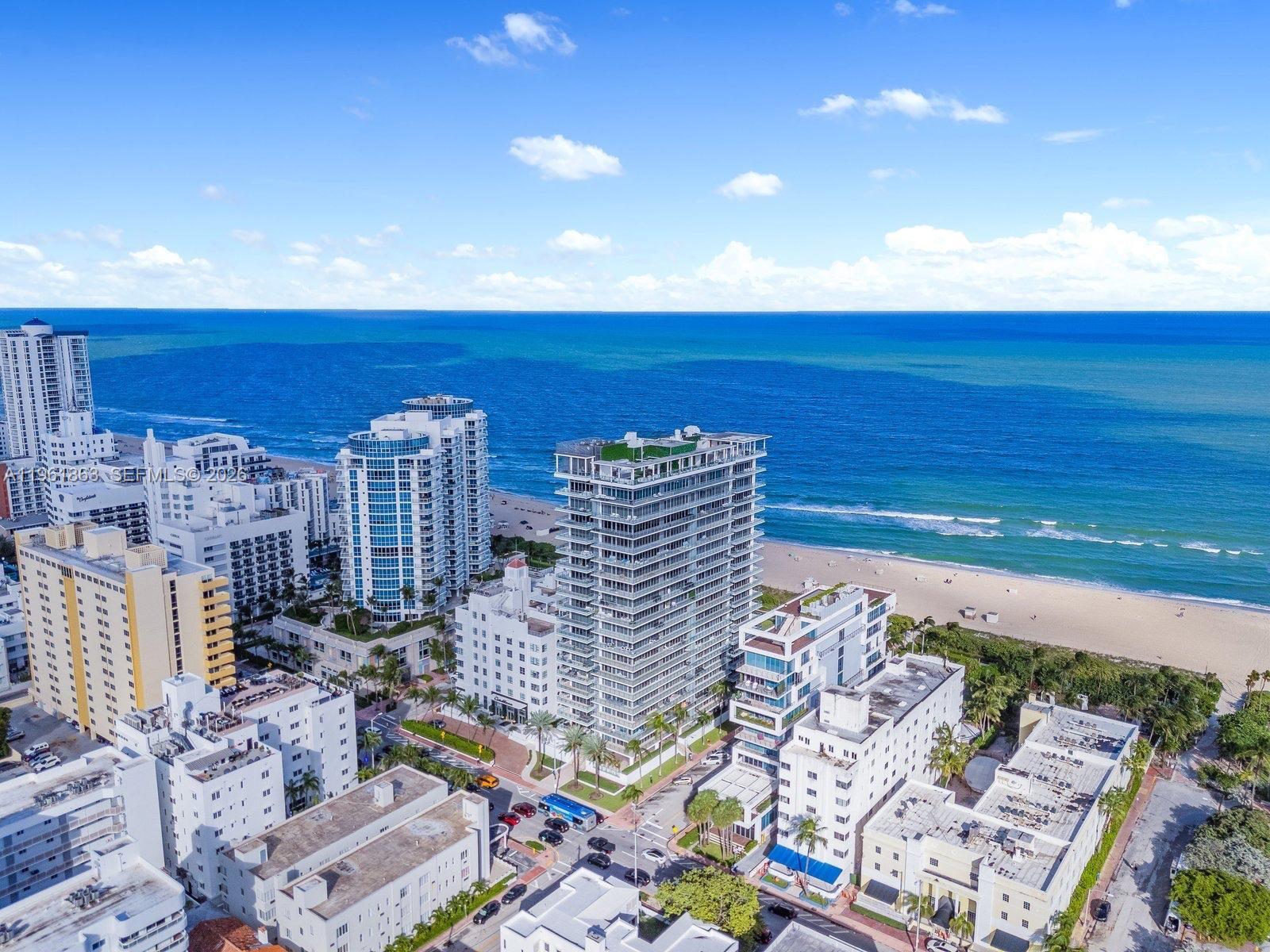 An aerial view shows high-rise residential buildings along a sandy beach and the ocean — 3739 Collins Ave # 207, Miami Beach FL 33140, MIAMI BEACH, FL