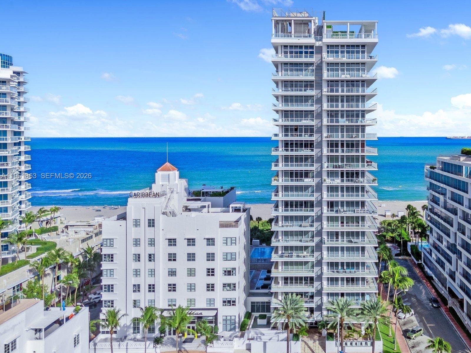 An aerial view shows a tall modern condominium tower next to a historic white building — 3739 Collins Ave # 207, Miami Beach FL 33140, MIAMI BEACH, FL