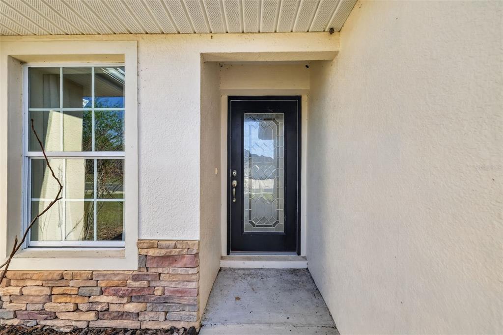 A front entryway features a black door with a glass insert and stone veneer siding — 4316 ABACO DRIVE, TAVARES, FL