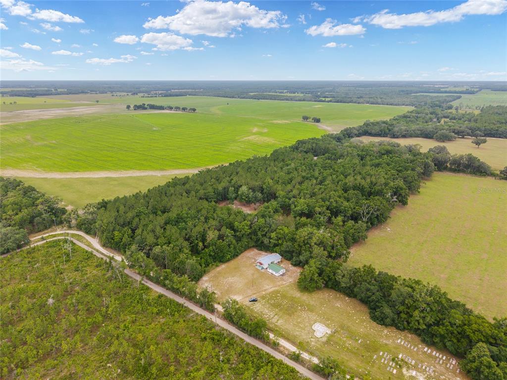 An aerial view shows a house situated on a large, rural property with surrounding fields — 0 SW 234TH STREET, NEWBERRY, FL
