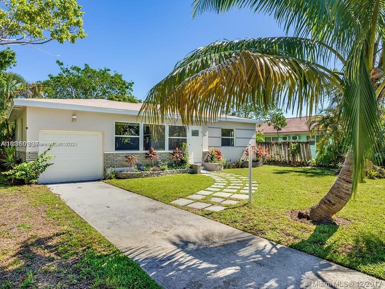 A single-story house with a white garage, stone accents, and a stone walkway in front — 1231 N 16th Ct, Hollywood FL 33020, HOLLYWOOD, FL