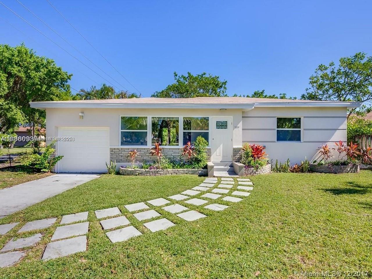 A single-story house with a white exterior, a garage, and a stone-accented front garden bed — 1231 N 16th Ct, Hollywood FL 33020, HOLLYWOOD, FL