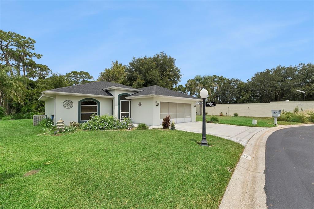 A single-story house with a light-colored exterior, a two-car garage, and a manicured lawn — 472 SWEETWATER WAY, HAINES CITY, FL
