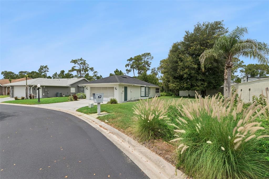 A single-story house with a garage and a grassy yard sits along a paved street — 472 SWEETWATER WAY, HAINES CITY, FL