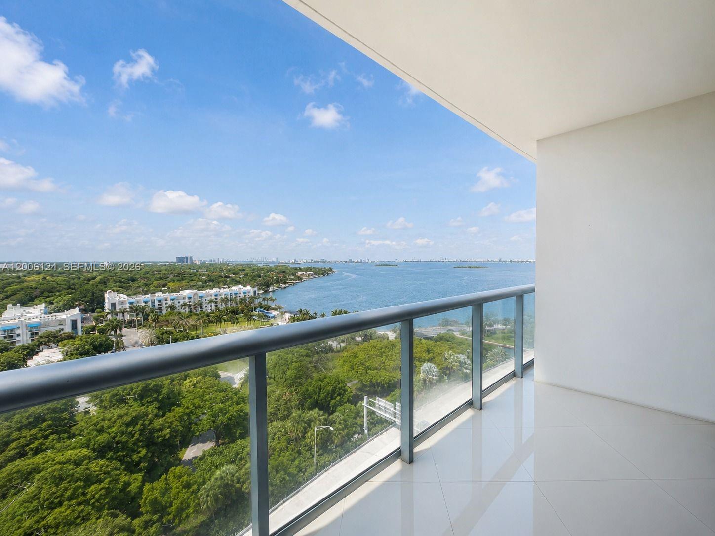 An aerial view of a tall, modern white high-rise building situated next to a bay — 601 NE 36th St # 1404, Miami FL 33137, MIAMI, FL