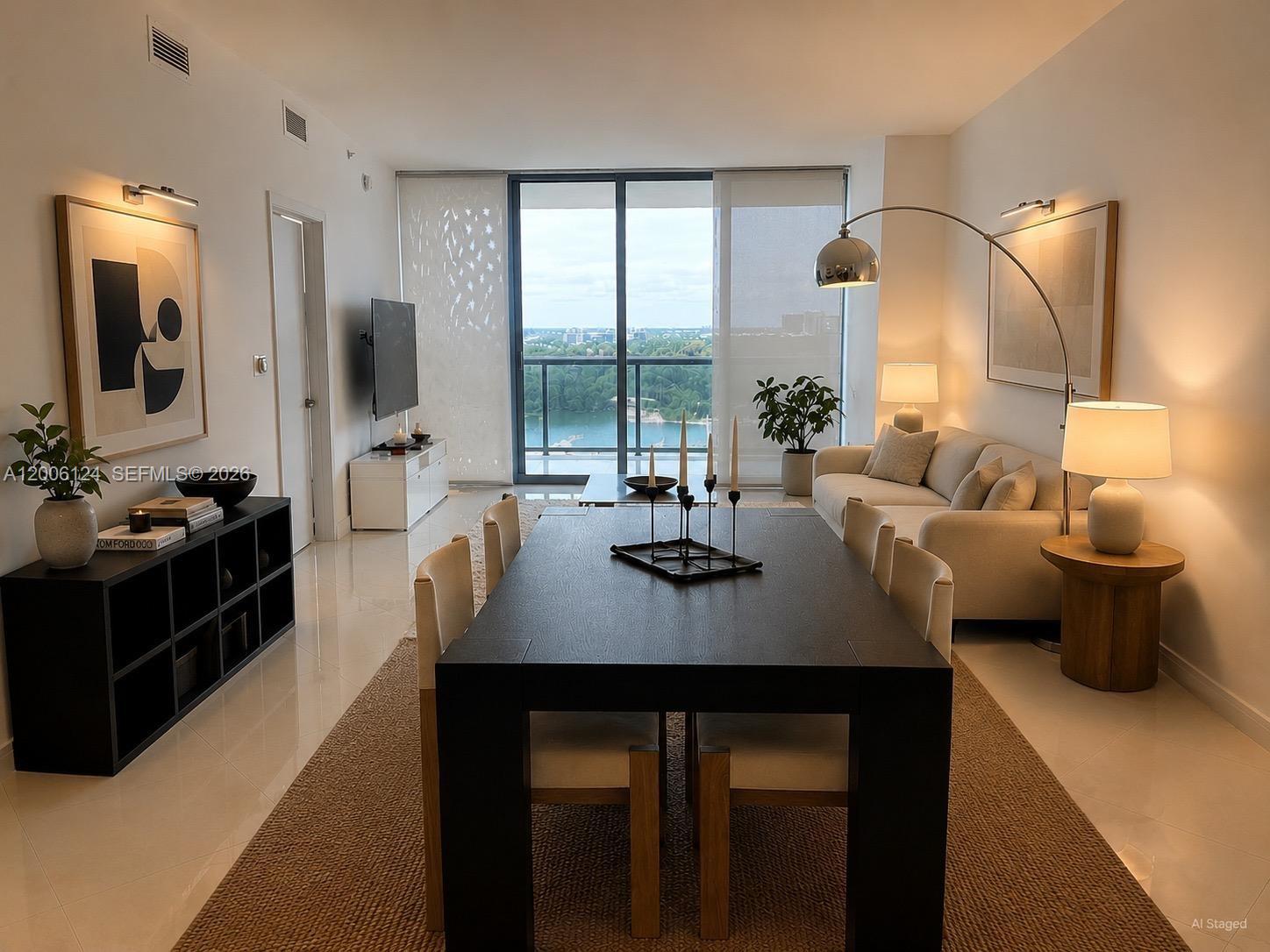 A modern living and dining room features a dark table, white sofa, and balcony view — 601 NE 36th St # 1404, Miami FL 33137, MIAMI, FL