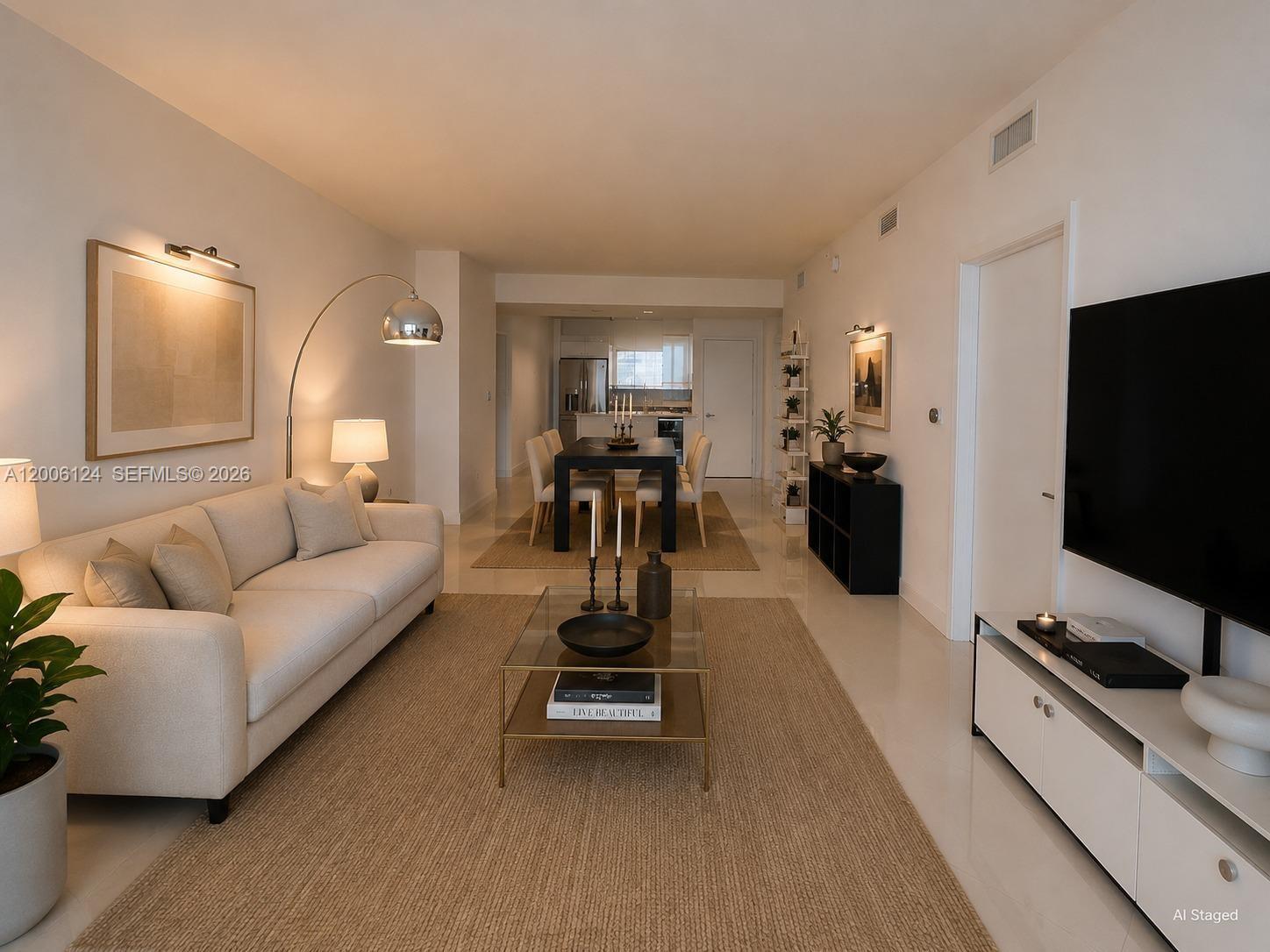 A bright, modern hallway features white tile floors, a wooden console table, and abstract wall art — 601 NE 36th St # 1404, Miami FL 33137, MIAMI, FL